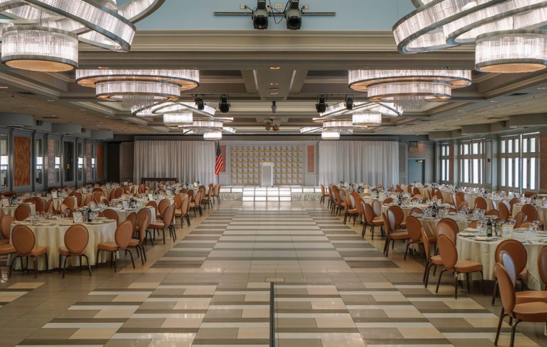 The ballroom set with rounds and a stage for a corporate event