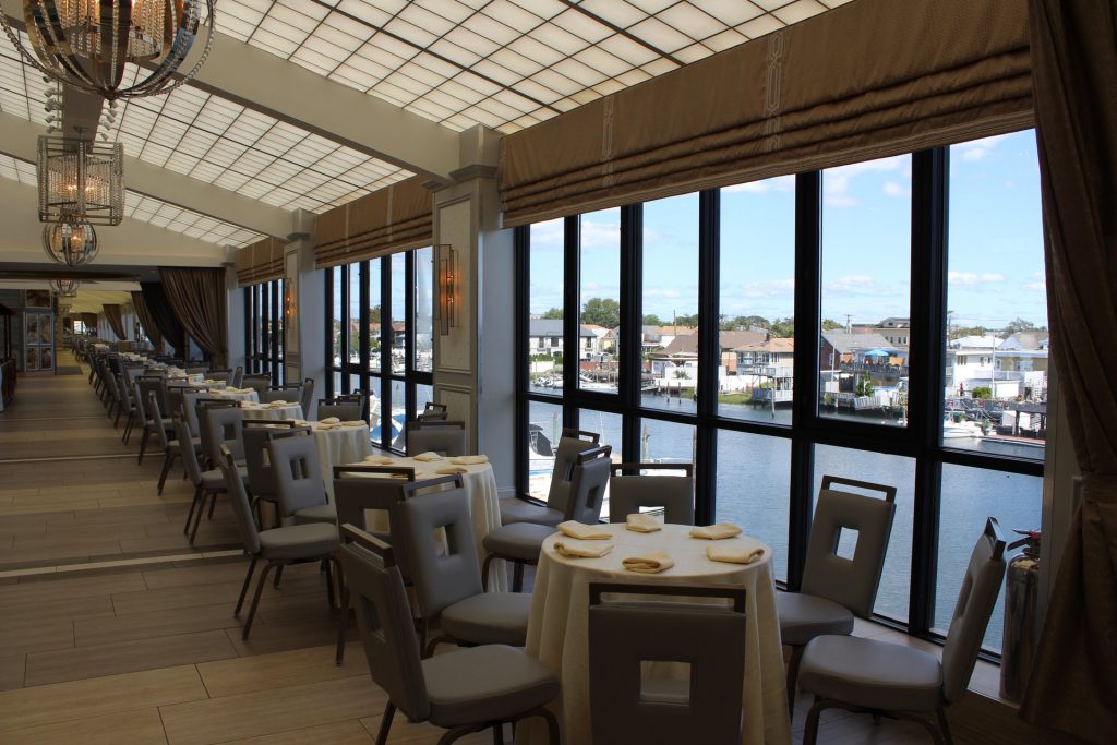 A table by The Promenade’s windows, the water and docks outside