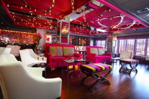 The Rose Lounge, with magenta sofas, white armchairs and the bar behind