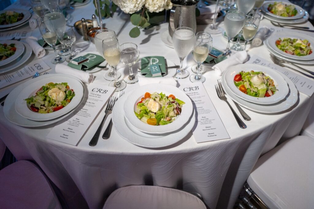 A table in service, plated first courses and menu cards