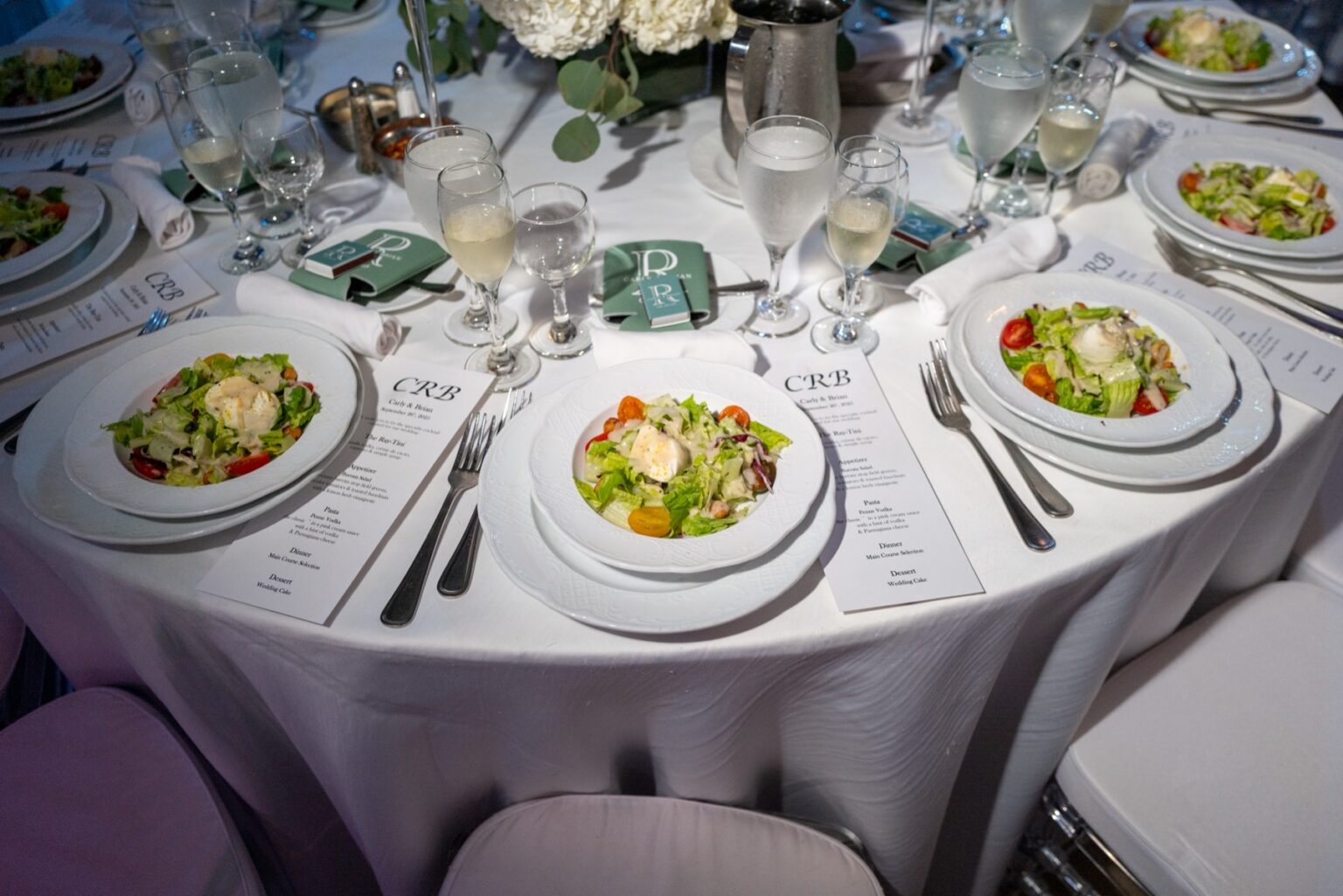 A table in service, plated first courses and menu cards