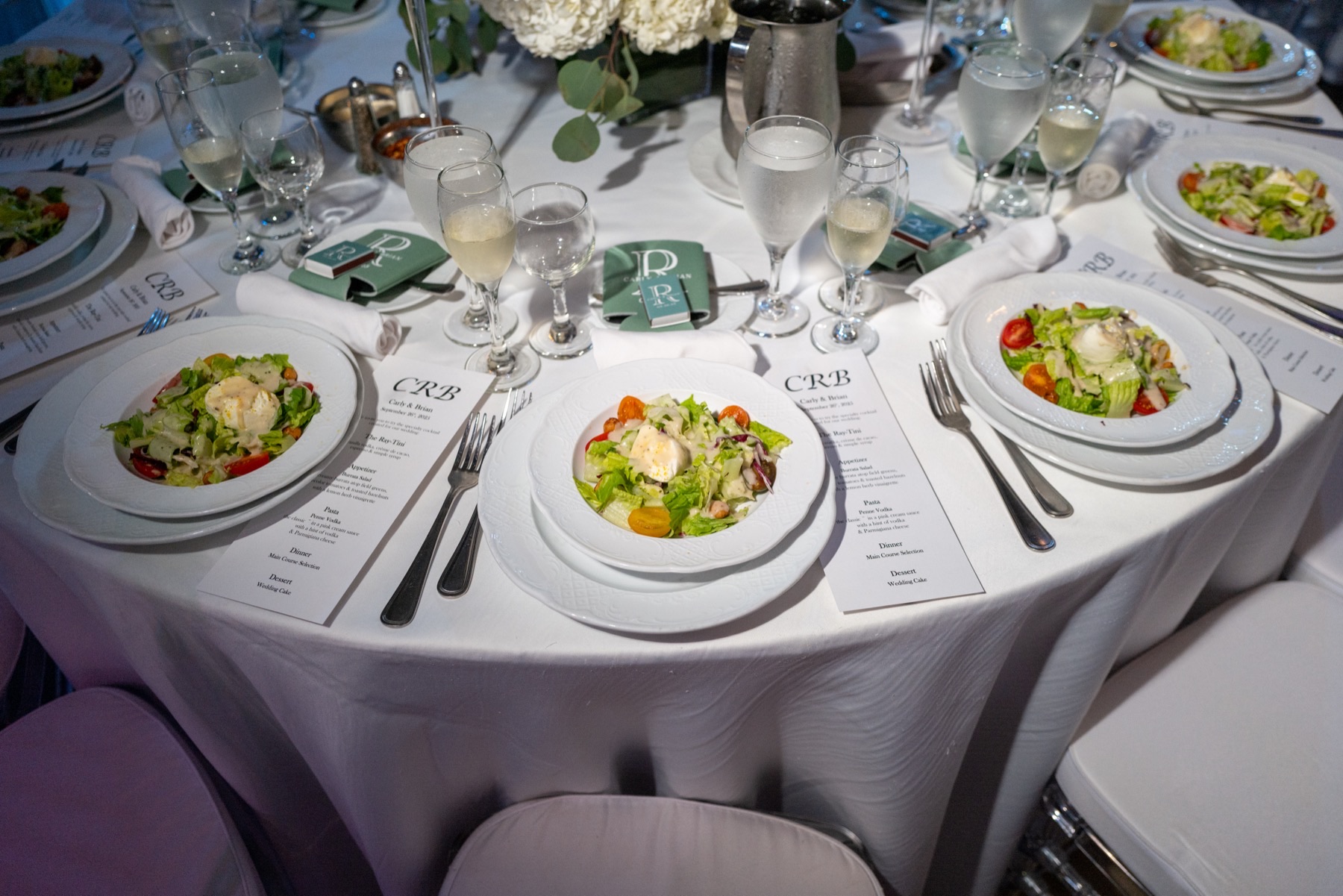 A table in service, plated first courses and menu cards